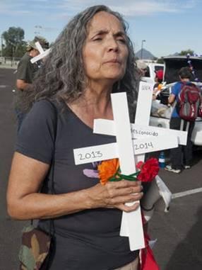 Preparing for a vigil, Garcia holds crosses recognizing two migrants who died while crossing the Arizona/Mexico border.